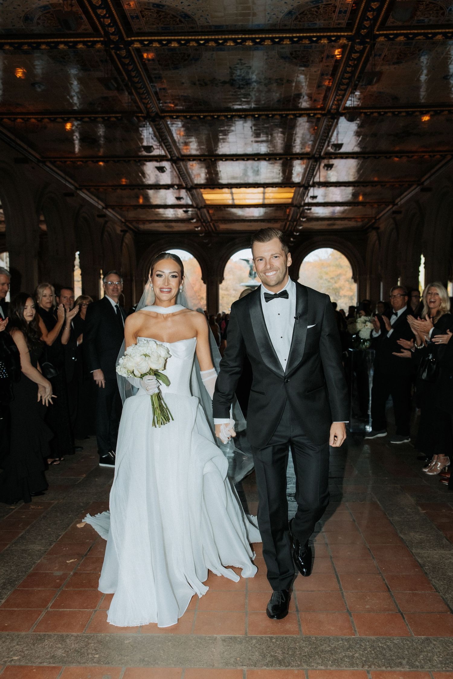 Bride and groom dance together on a rustic tiled floor during their wedding reception celebration.