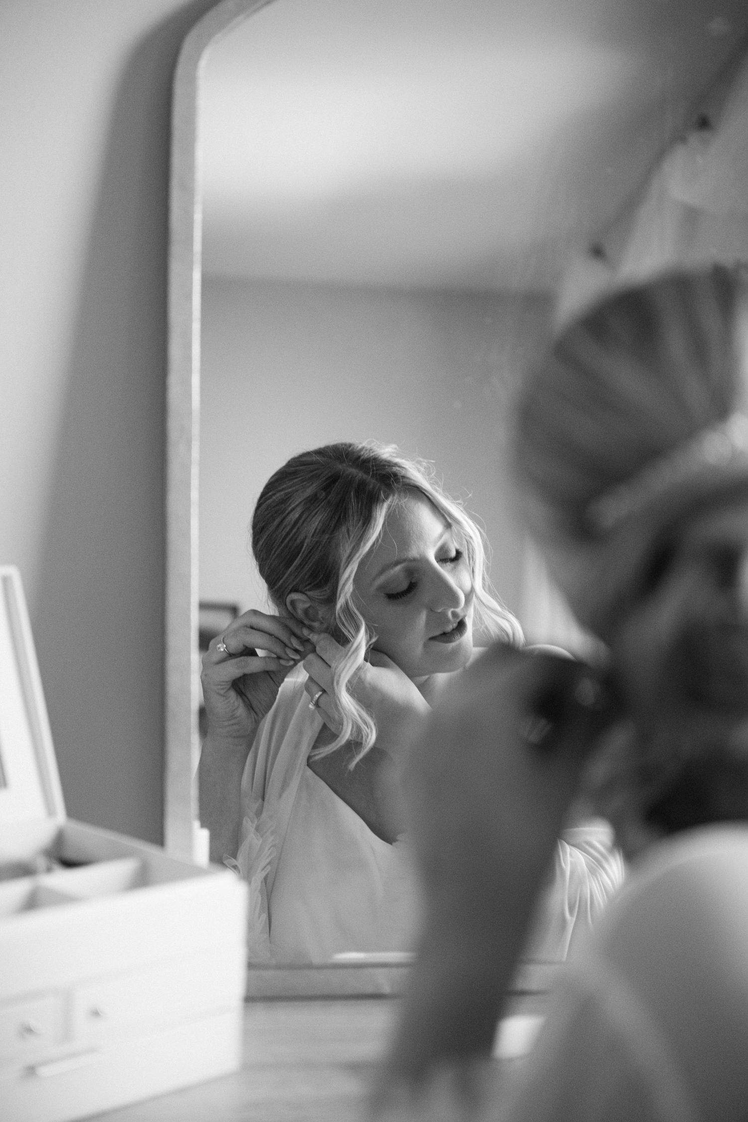 A sequence of soft focus shots showing makeup being applied in a brightly lit room with white tones.
