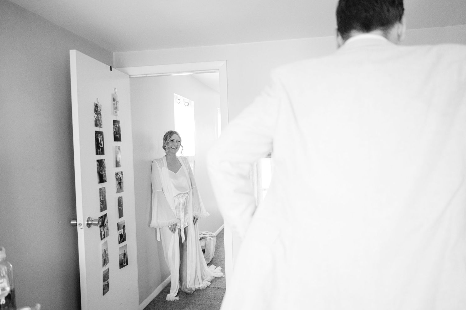 Six adjacent black and white photographs show a figure in white moving within an interior space.