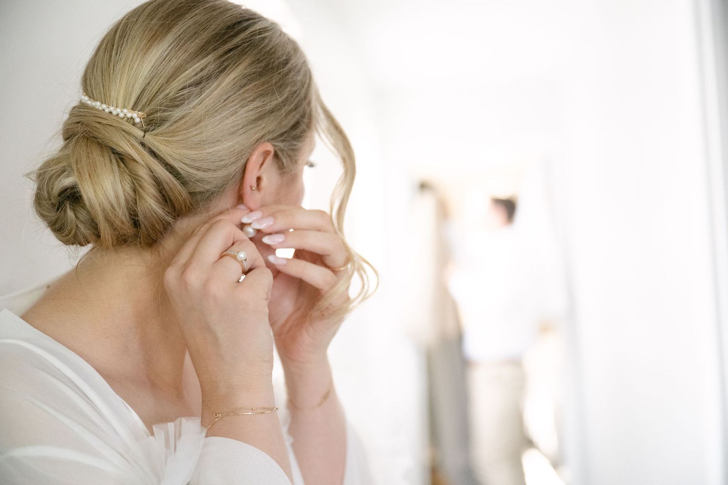A woman gets ready for her wedding day with soft lighting and elegant details in the getting ready room.