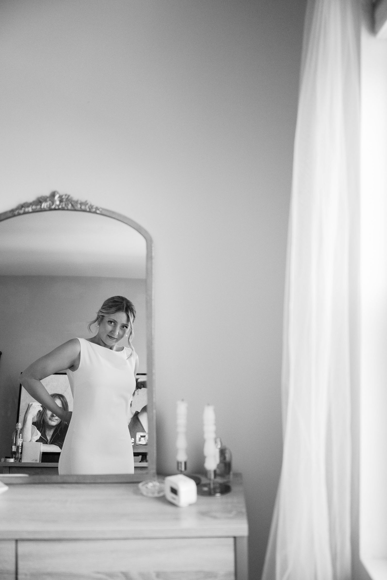 Black and white photos of a mirror and vanity during wedding preparation moments.