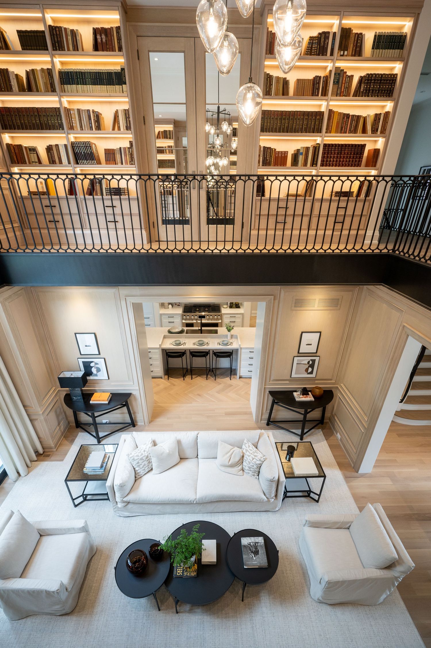 Interior photo of a luxury home showcasing a wall library and a bright, spacious living room.