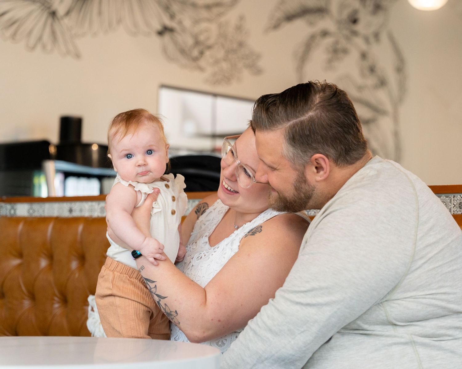 A tender moment shared between parent and baby in a relaxed indoor setting with soft lighting.