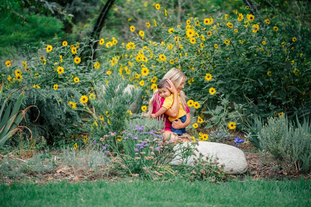 A mother loving embraces son in garden of wildflowers in Orange County, California.