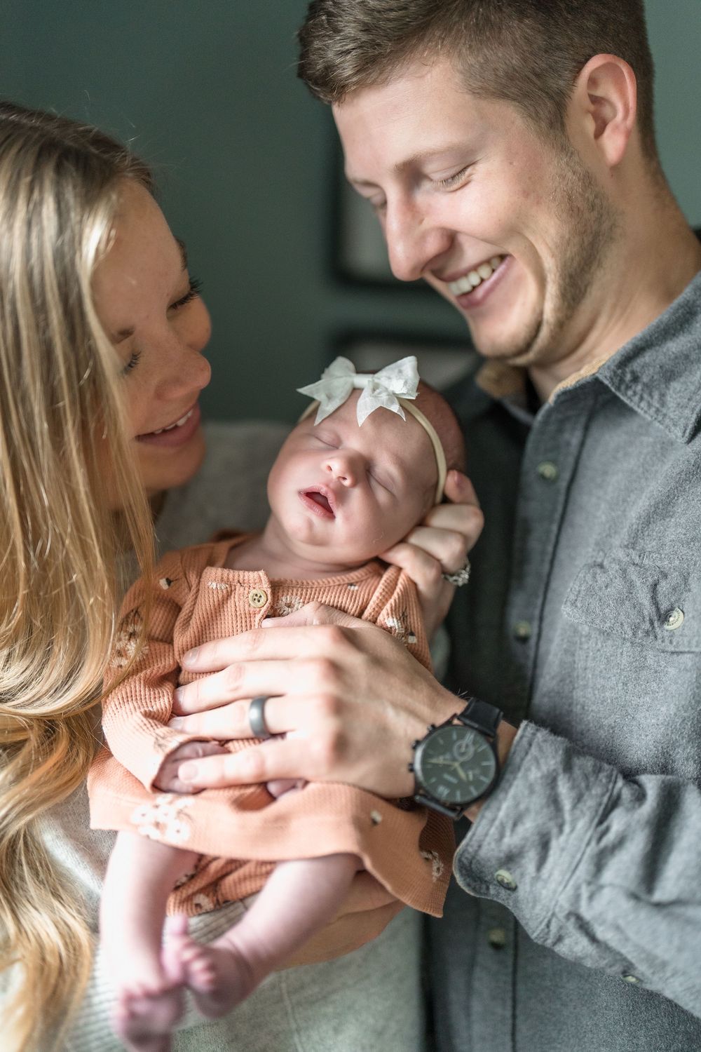 Parents share joyful moments with their newborn baby in a series of tender indoor family photos in Cuyahoga Falls, Ohio Newborn Session.