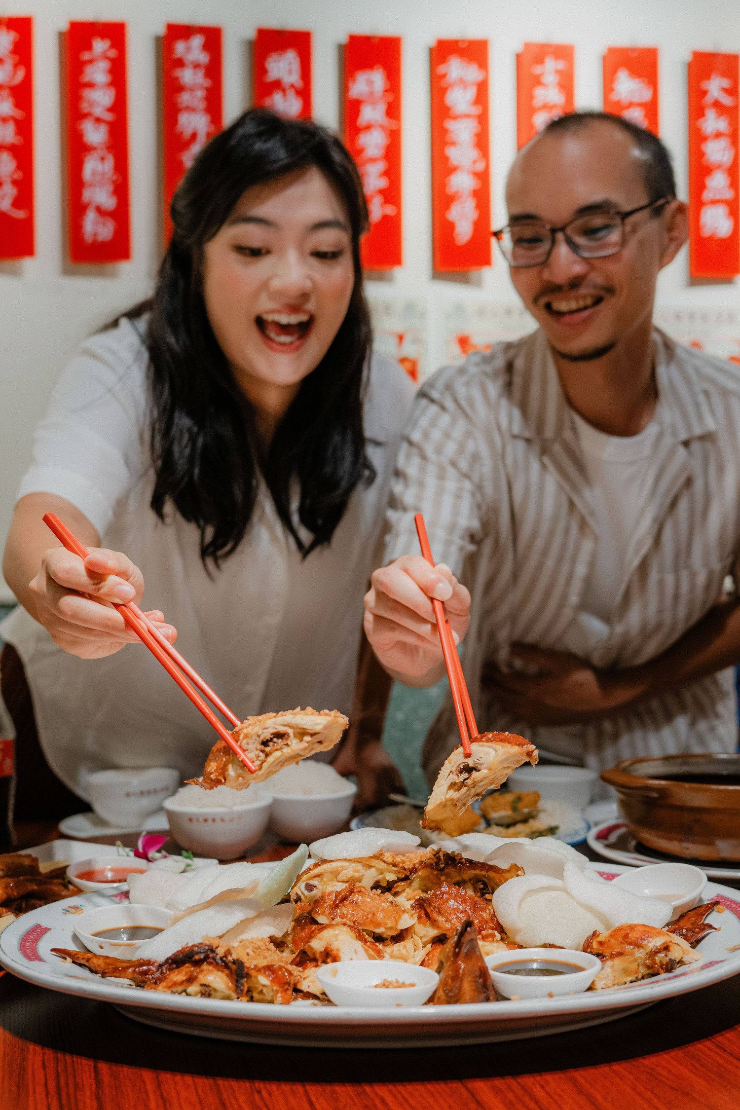 Two people sharing a festive Chinese dinner with seafood and various dishes on a round table.