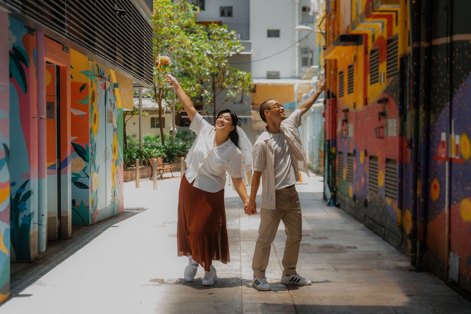People stand in a brightly painted alleyway filled with colorful murals and graffiti art.