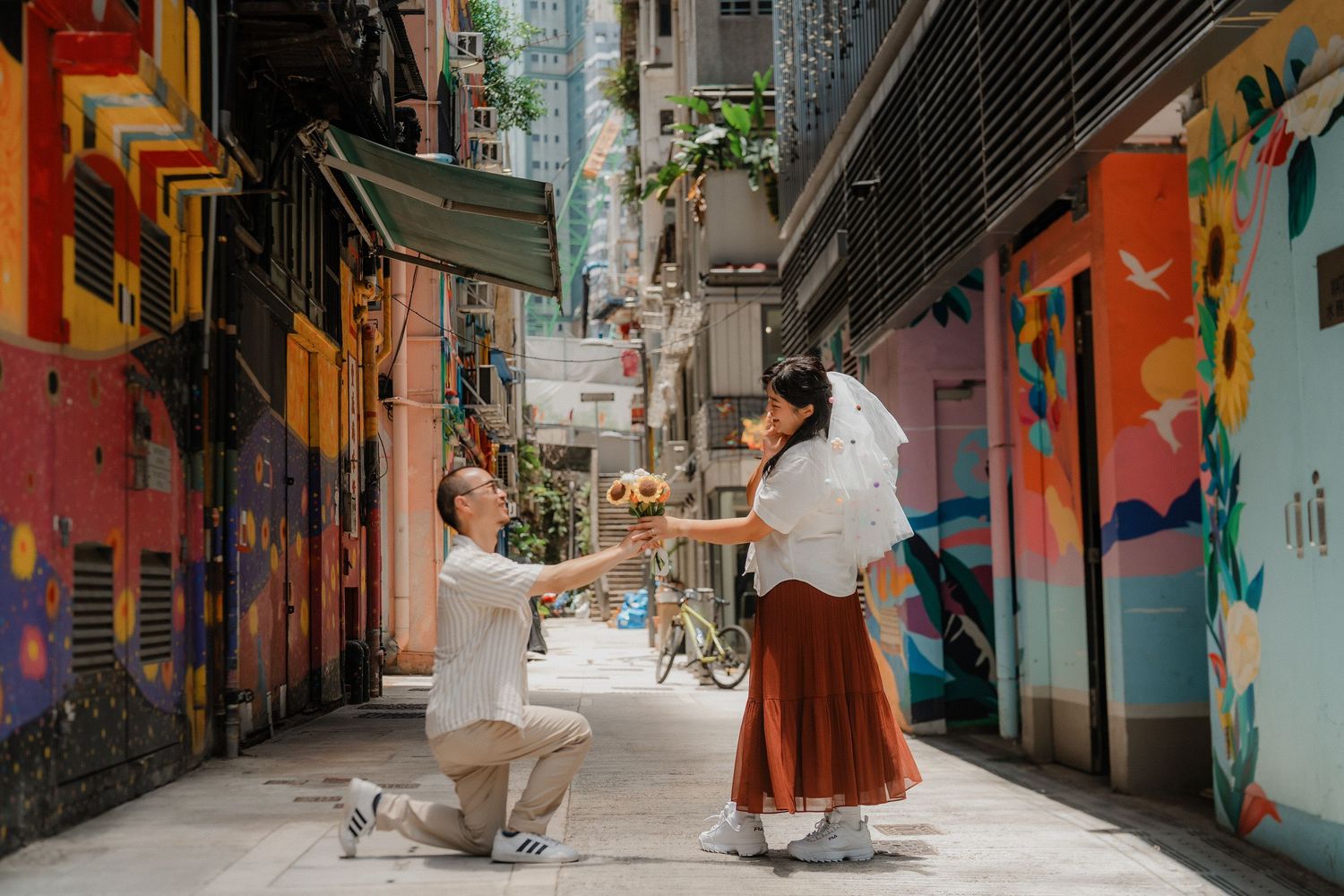 A romantic proposal scene on a colorful alley with street art murals and vibrant walls in an urban setting.