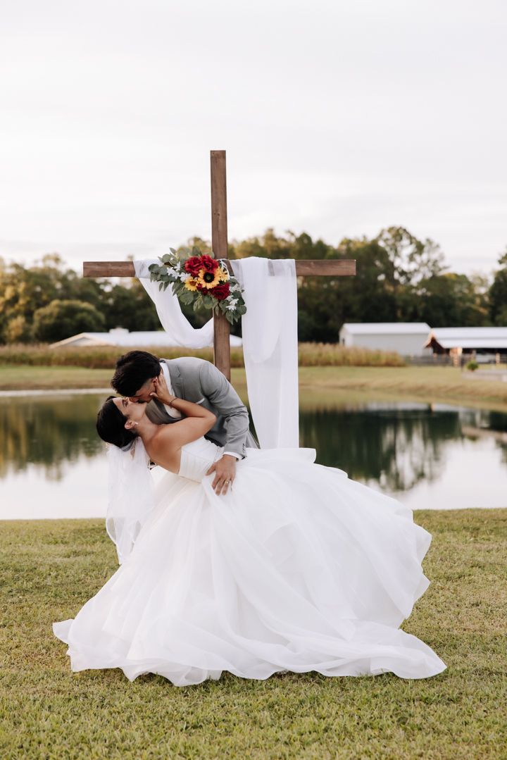 A couple poses across three artistic photos of a dip kiss in front of a lake during sunset.