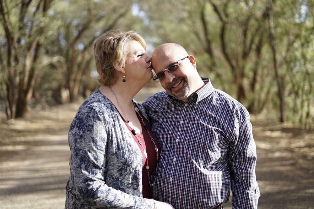 Couple walking together on a tree-lined path in natural lighting. alt="Professional  photography in Lubbock TX by H & Co. Creative