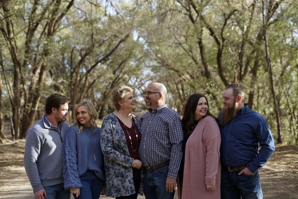 Group walking together along a shaded trail surrounded by trees. alt="Professional family photography in Lubbock TX by H & Co. Creative