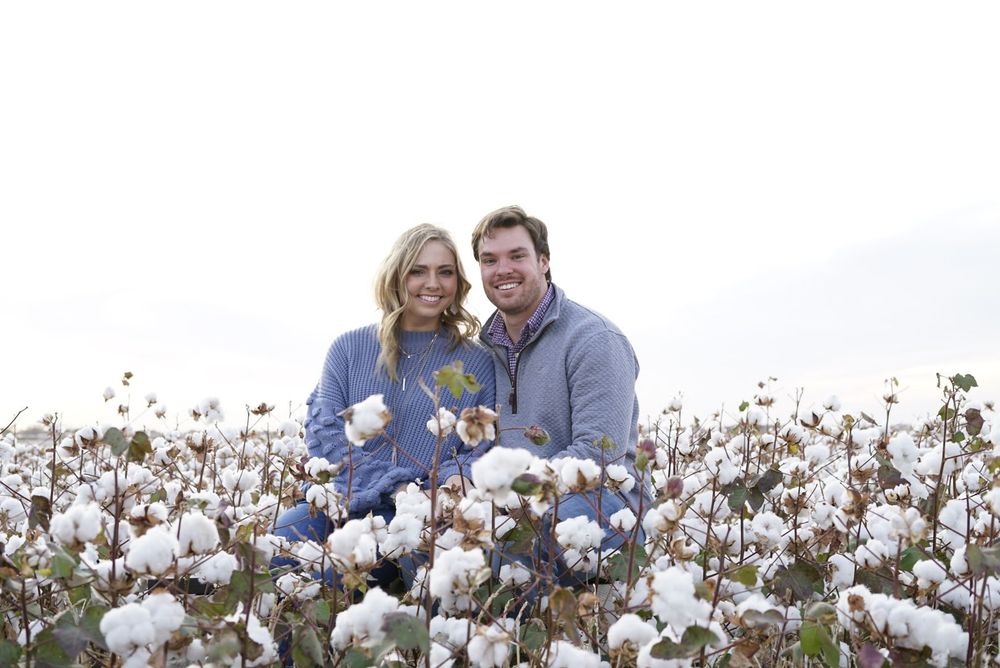 Couple embracing in a blooming cotton field on a bright sunny day. alt="Professional  photography in Lubbock TX by H & Co. Creative