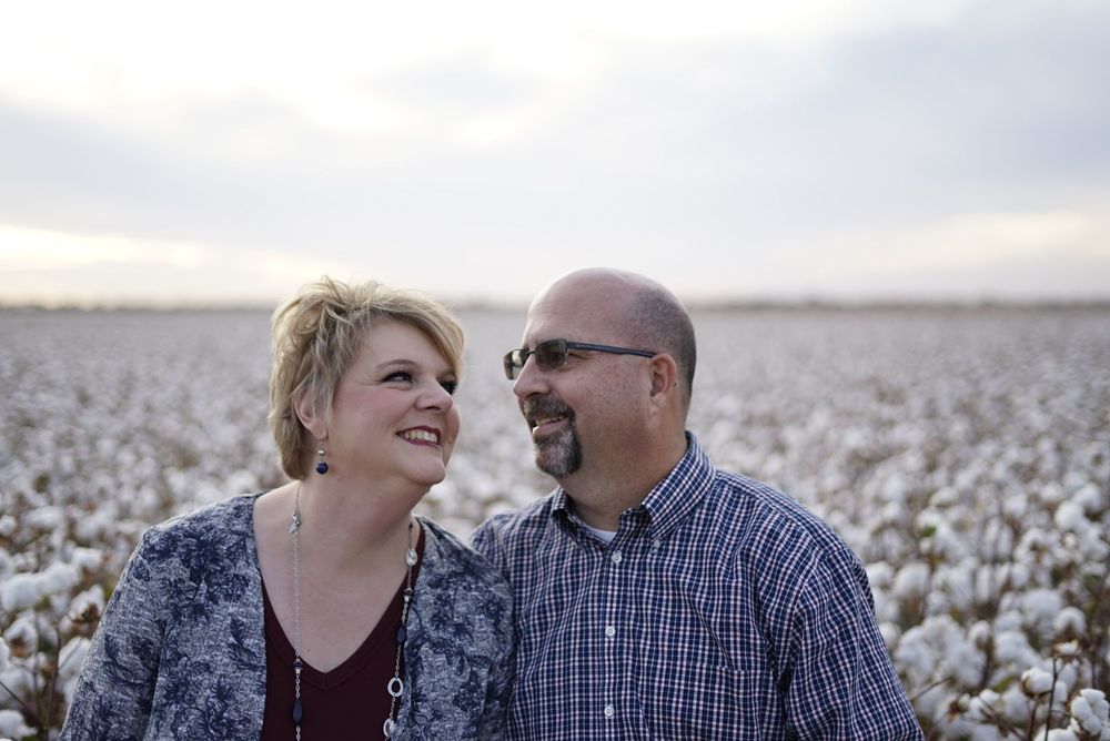 Couple sharing a loving moment together in a cotton field during golden hour. alt="Professional  photography in Lubbock TX by H & Co. Creati