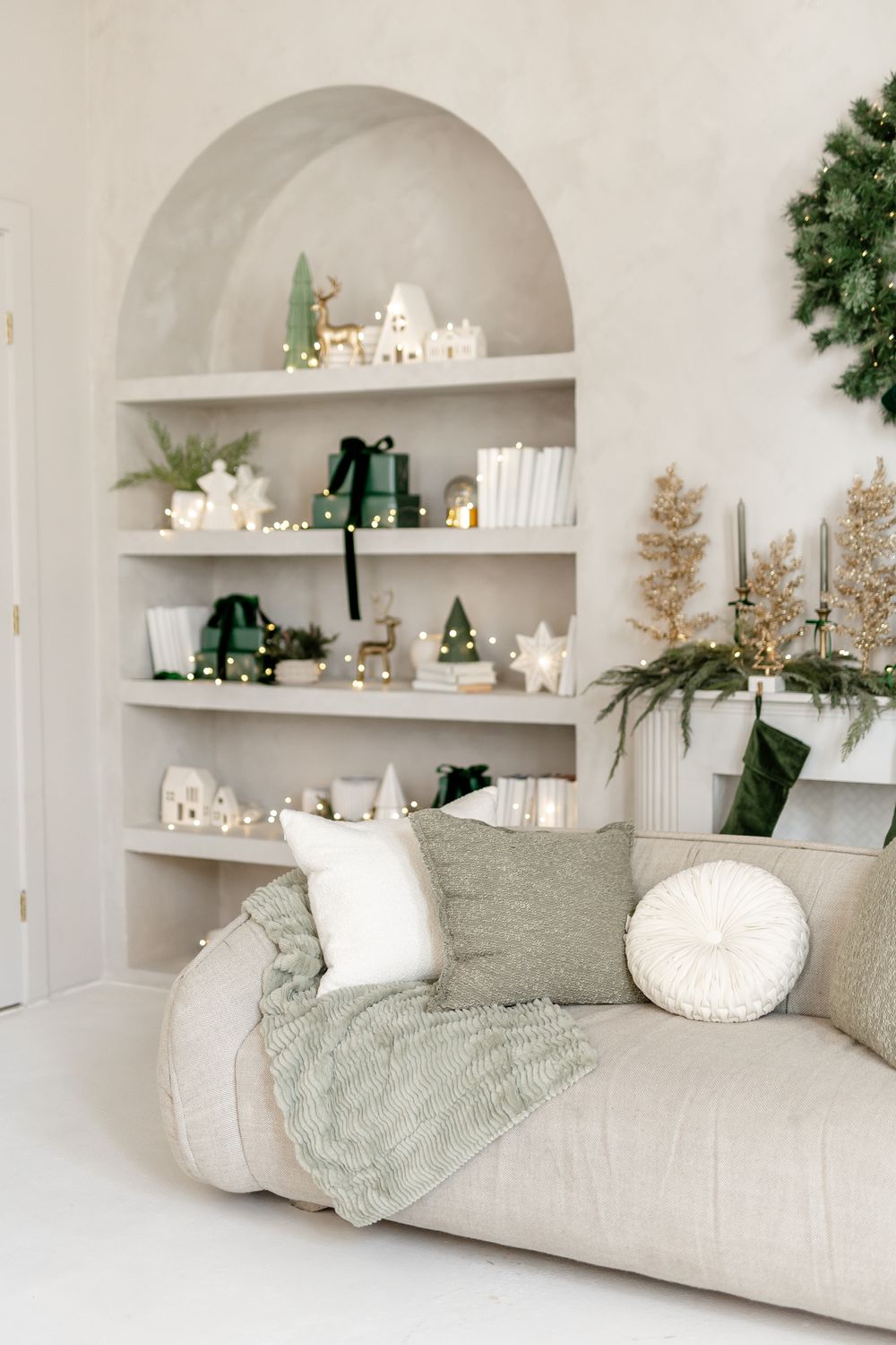 Cozy reading nook with white built-in shelves, sage green accents, and festive Christmas decorations.