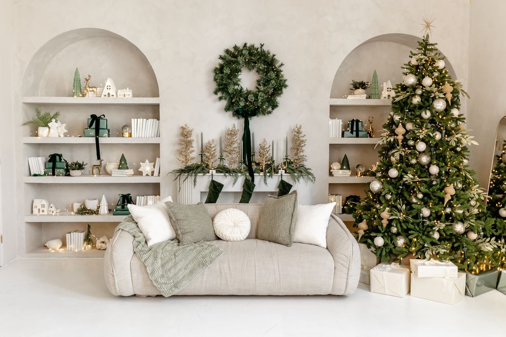 White built-in shelves decorated with Christmas wreaths, lights, and a decorated tree create a cozy holiday display.