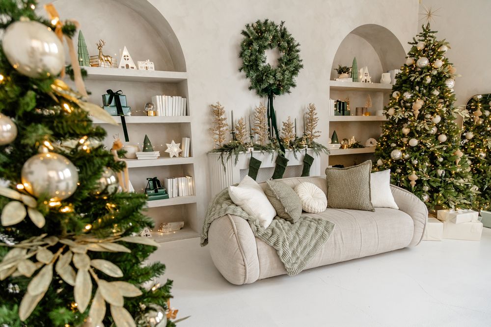 White arched built-in shelving decorated with holiday decor, greenery and warm lights for Christmas.