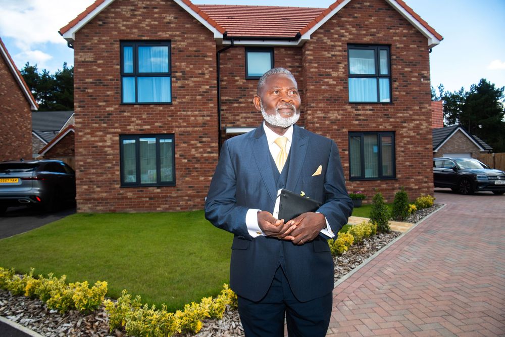 Commercial portrait of property developer Francis Sheuk-Fobbie outside new homes in Ipswich, Suffolk