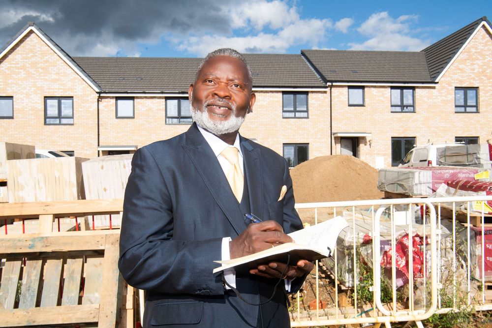Commercial portrait of property developer Francis Sheuk-Fobbie outside new homes in Ipswich, Suffolk