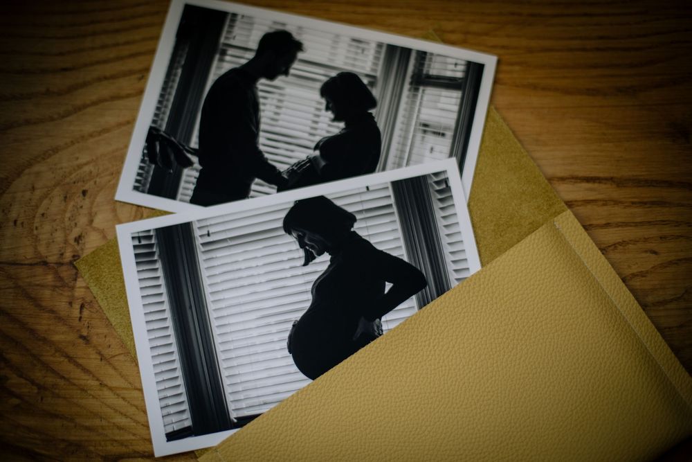 A silhouetted figure in multiple black and white artistic photographs arranged in a row against a wood grain surface.