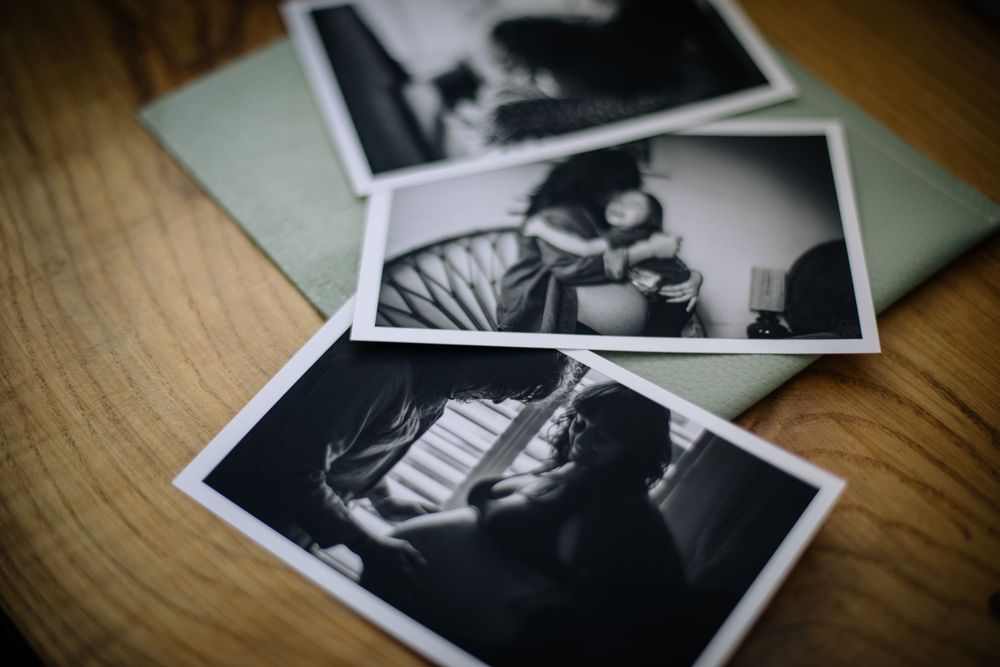 Black and white vintage photographs scattered on a wooden surface create a nostalgic display.