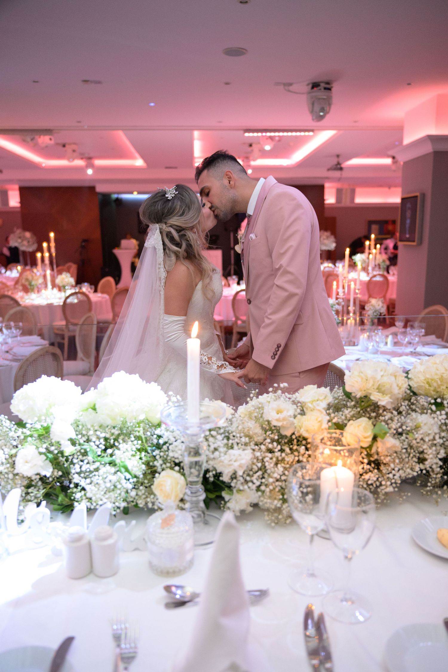 Black and white photo of a tender moment between a couple at their wedding ceremony in an elegant venue.