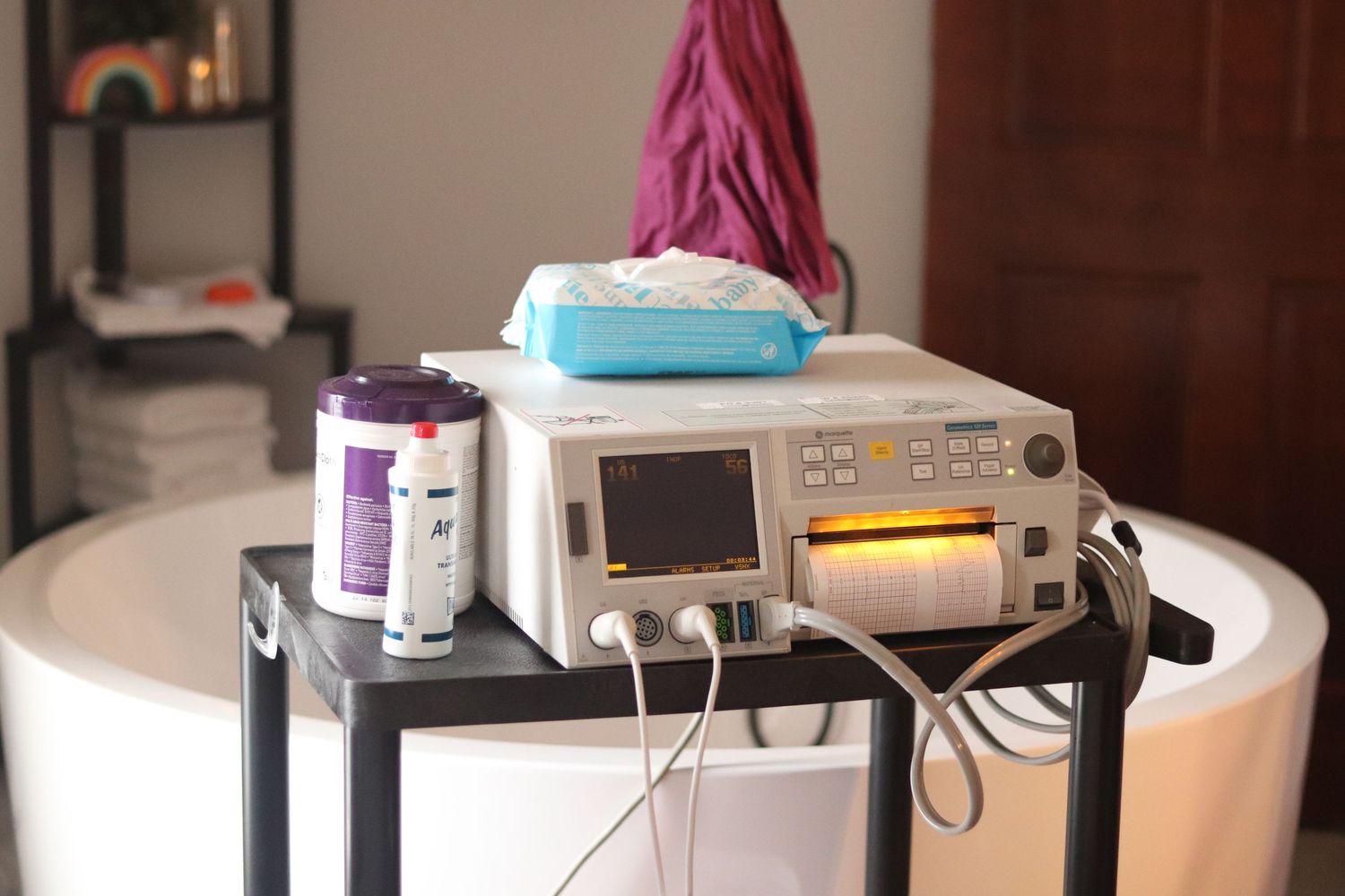 Medical monitoring equipment and supplies displayed on a small table in what appears to be a hospital room setting.