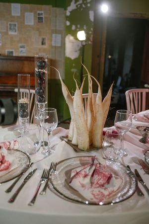 Elegant table setting with pink floral napkins, wine glasses, and silverware at a formal dinner party restaurant.