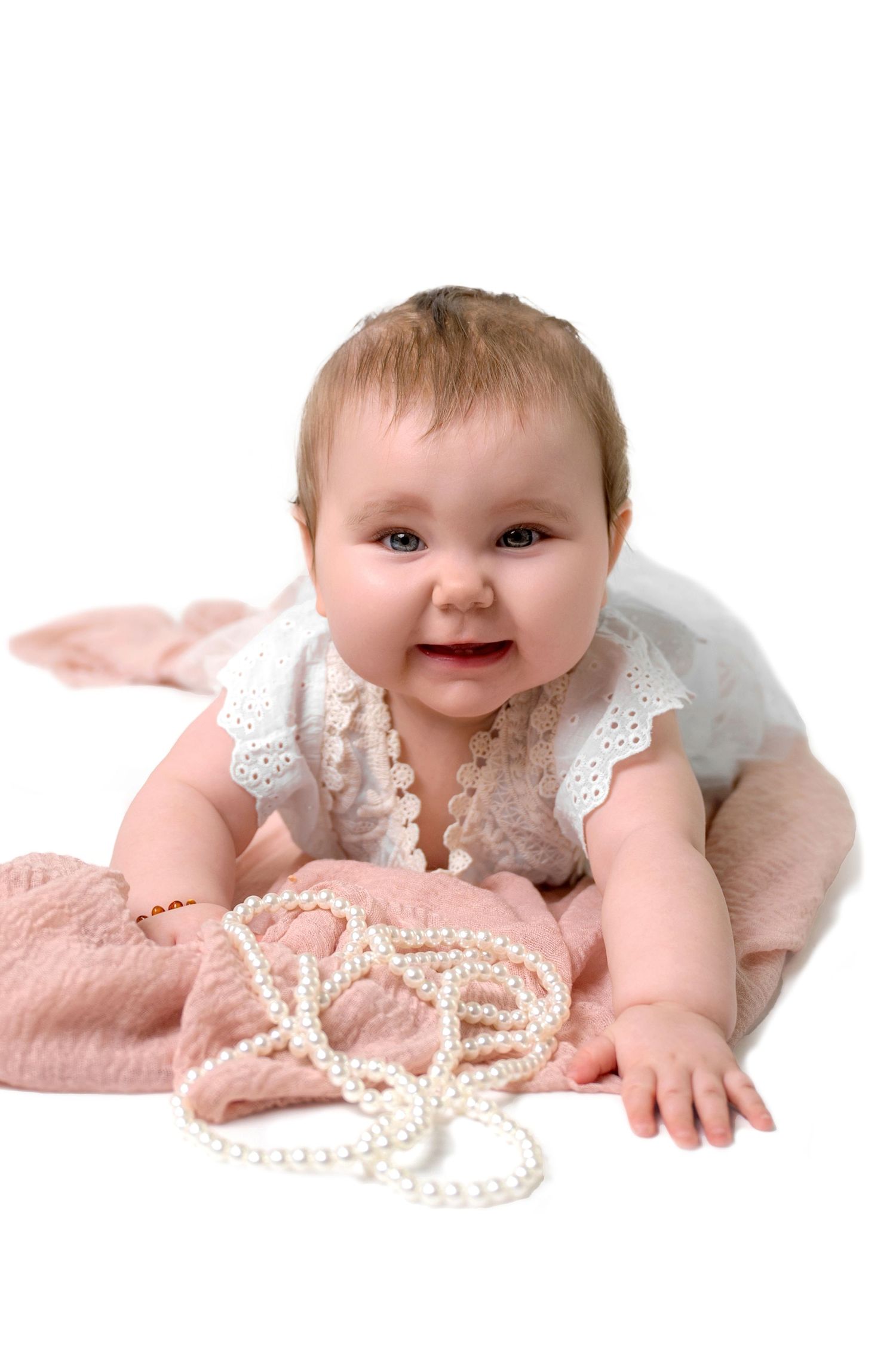 A compilation of milestone photos shows a baby growing month by month, sitting on a textured blanket with numbered blocks and flowers.