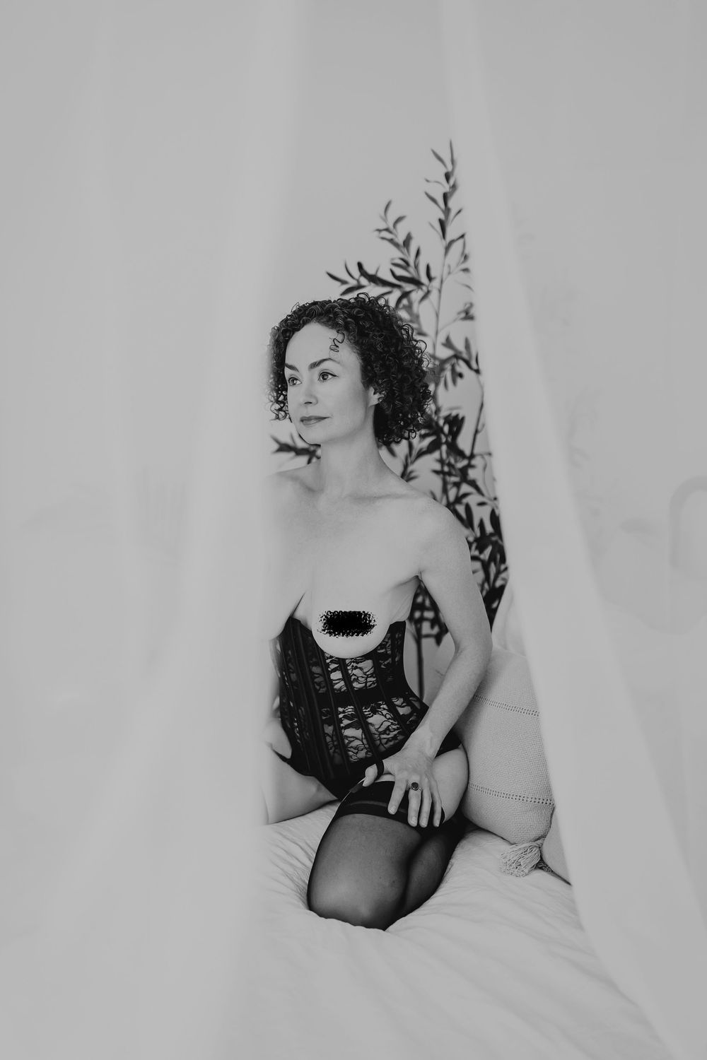 Artistic black and white boudoir photoshoot featuring dramatic poses against a light background.