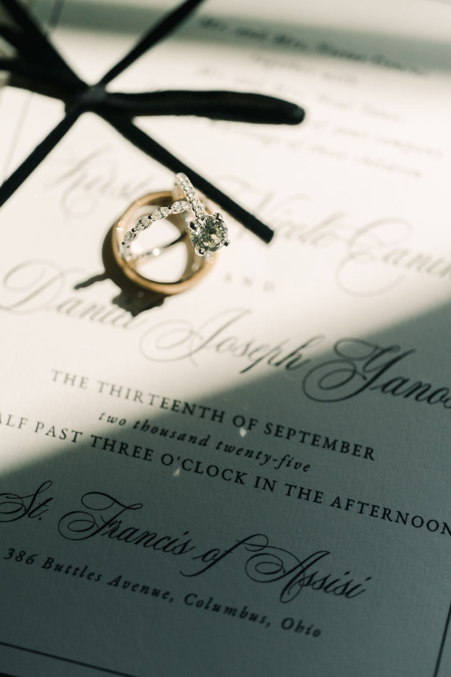 Wedding invitation details with rings and elegant calligraphy.