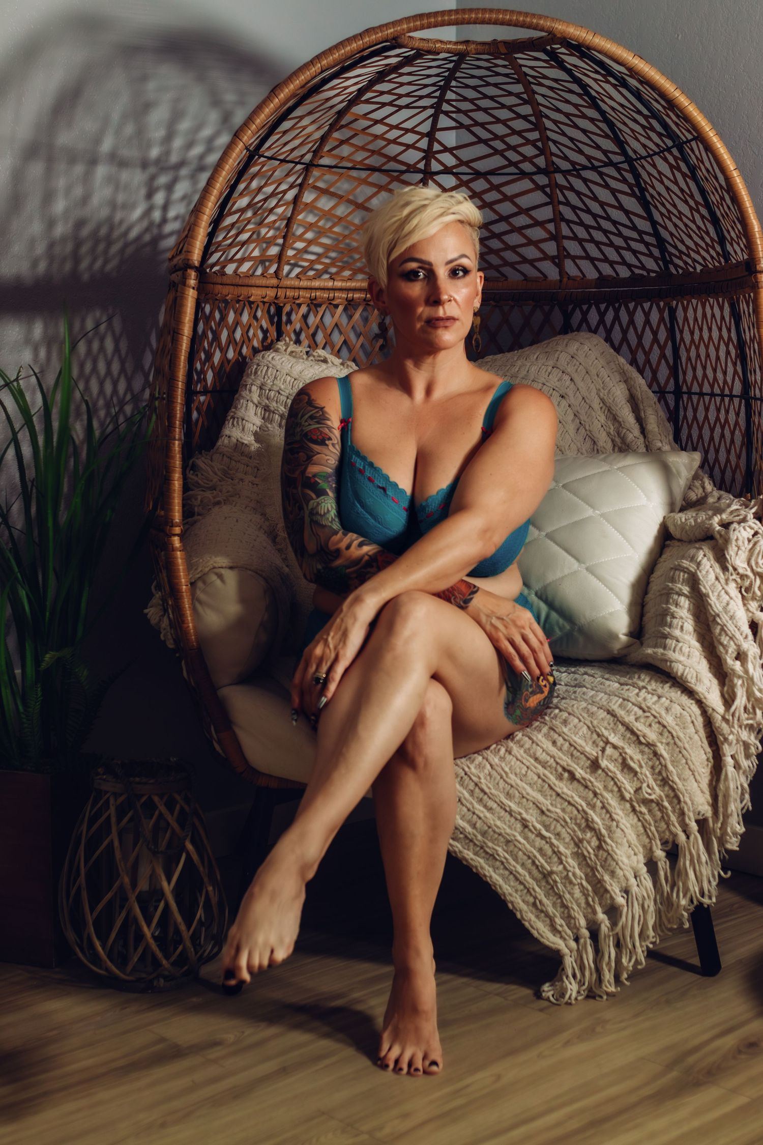Confident client seated in blue lingerie during a Fort Worth boudoir session at Lock and Key Photography.