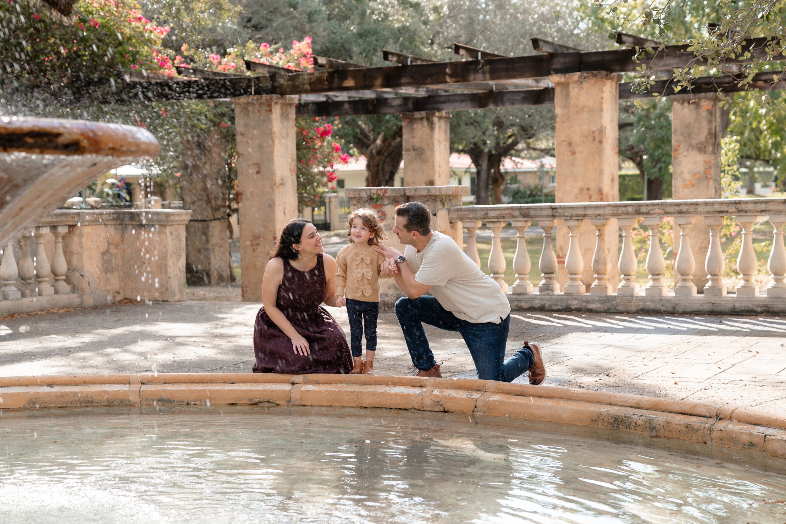 People relax and socialize in a rustic stone hot spring pool surrounded by natural scenery.