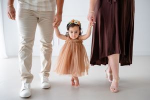 Cropped view of people's legs and feet walking together in coordinated beige and brown outfits.