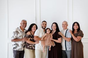 A series of diverse people standing together against a white background in casual attire for a group photo shoot.