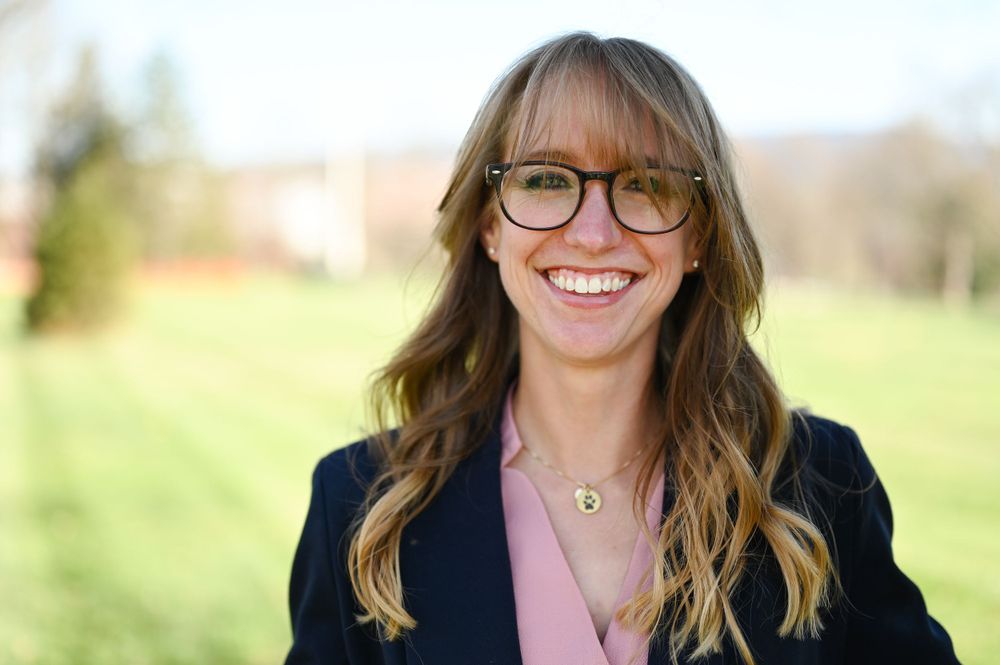 Business portrait series showing someone in glasses and blazer with a warm, professional smile.