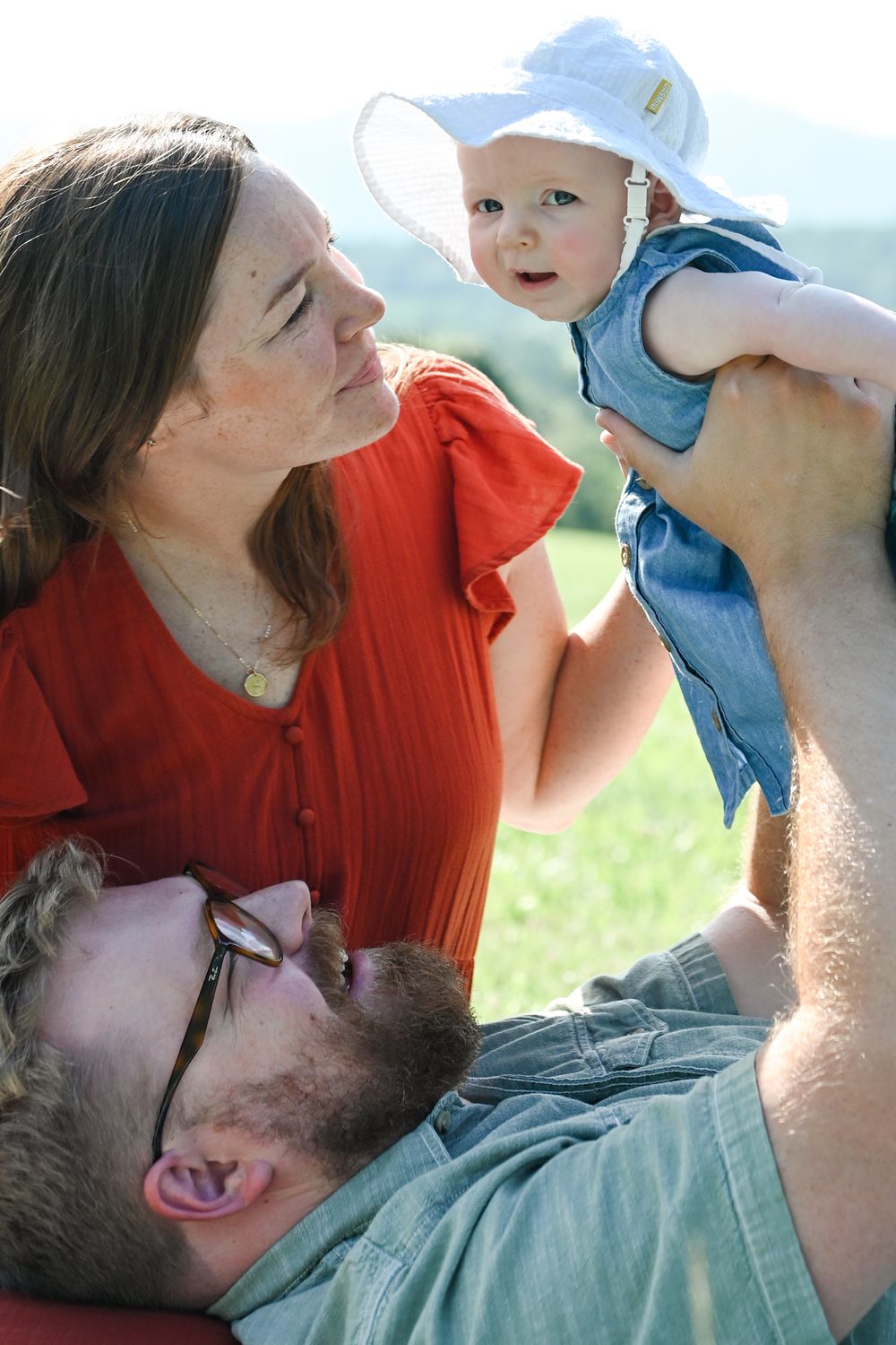 A family enjoying a playful moment together outdoors on a sunny day, expressing joy and connection.