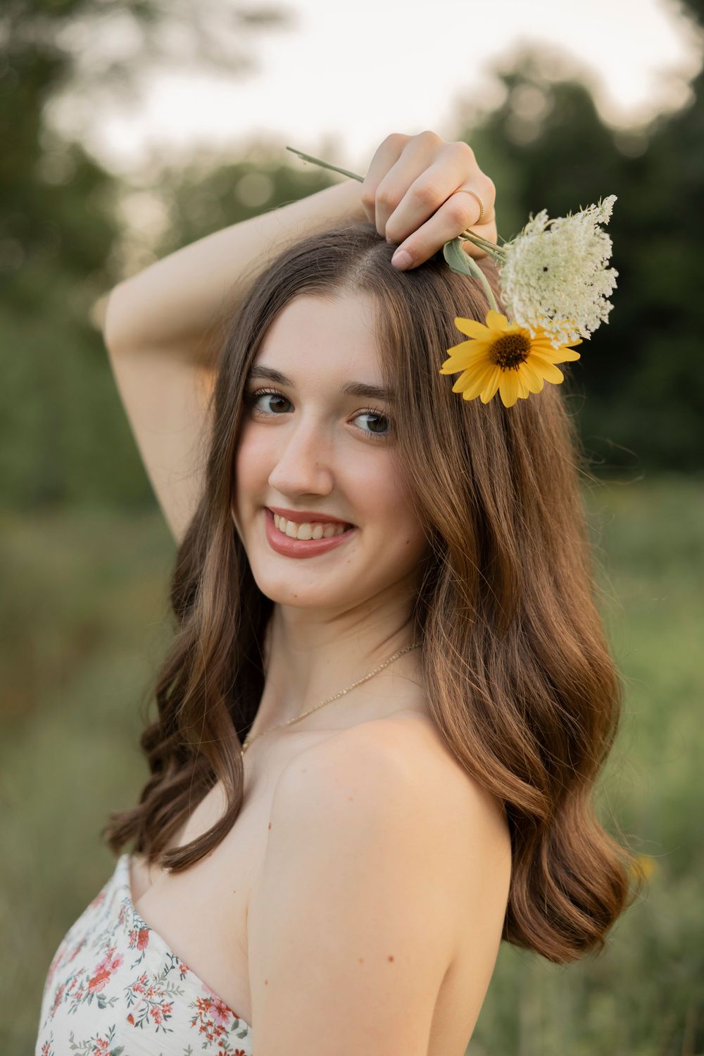 An avondale high school senior portrait in a wildflower field in Beverly Hills michigan wearing a floral dress.