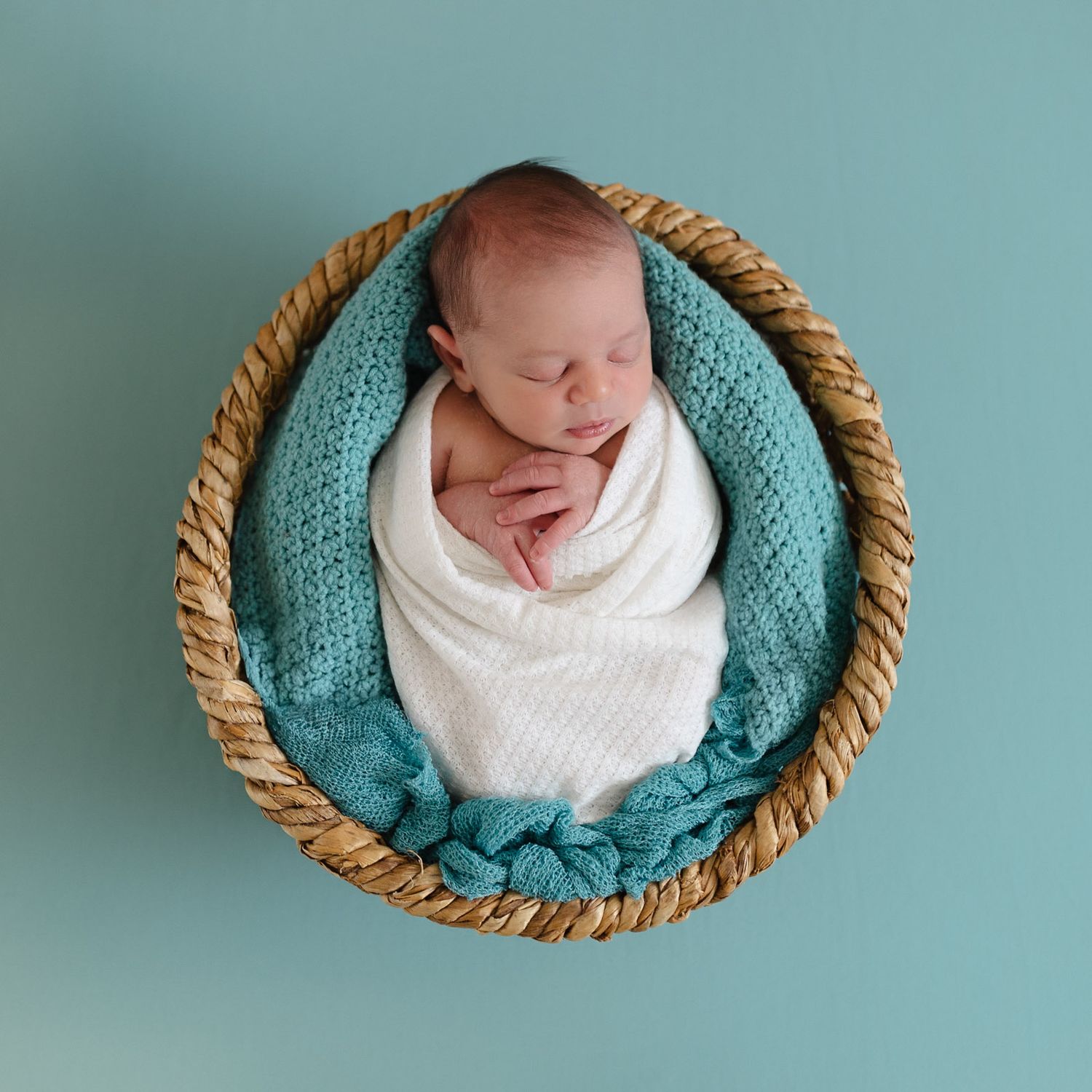 Creative newborn photography sequence showing baby swaddled in teal blanket in woven basket with minimalist background.