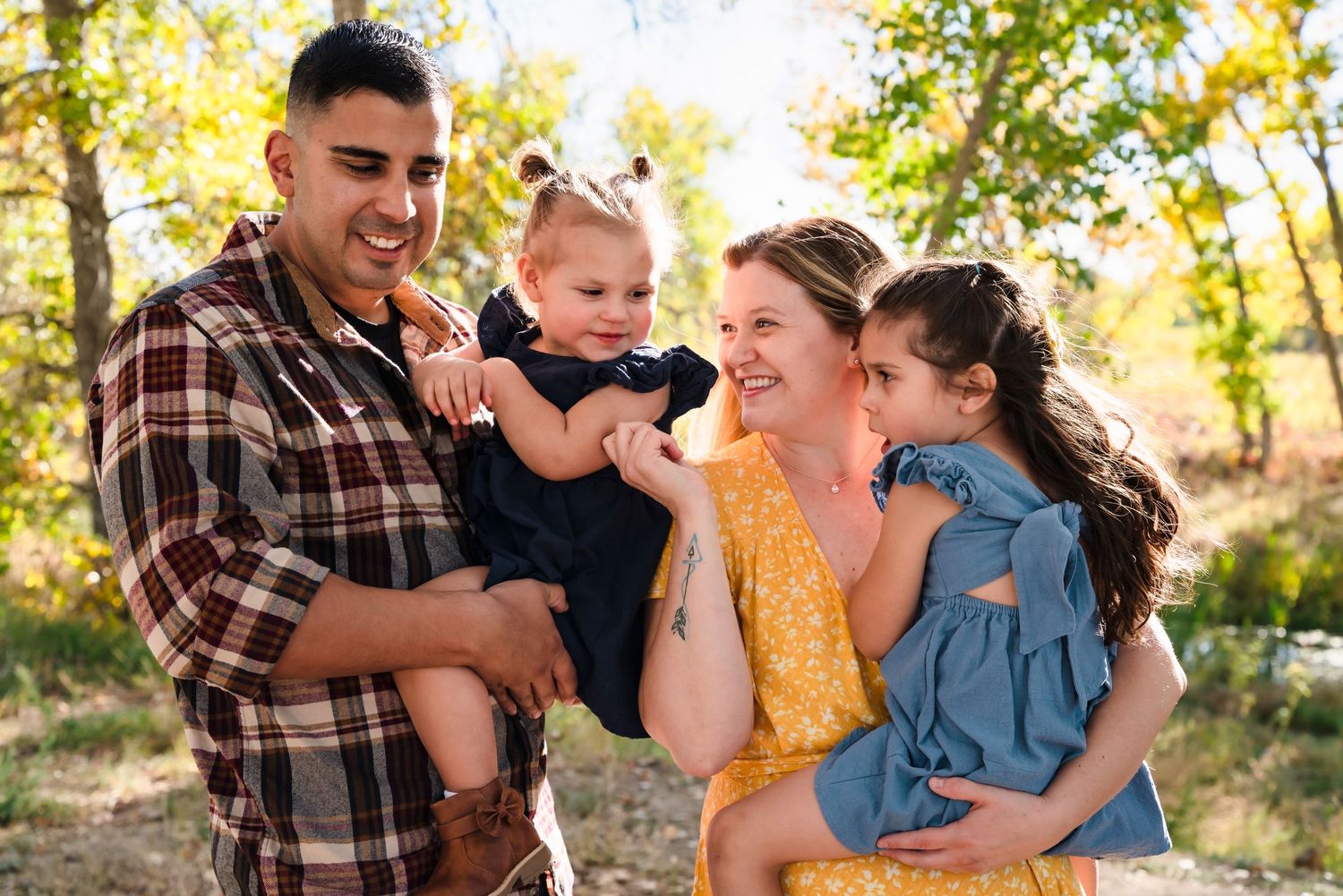 Happy family enjoying a fall day outdoors together in natural autumn setting.