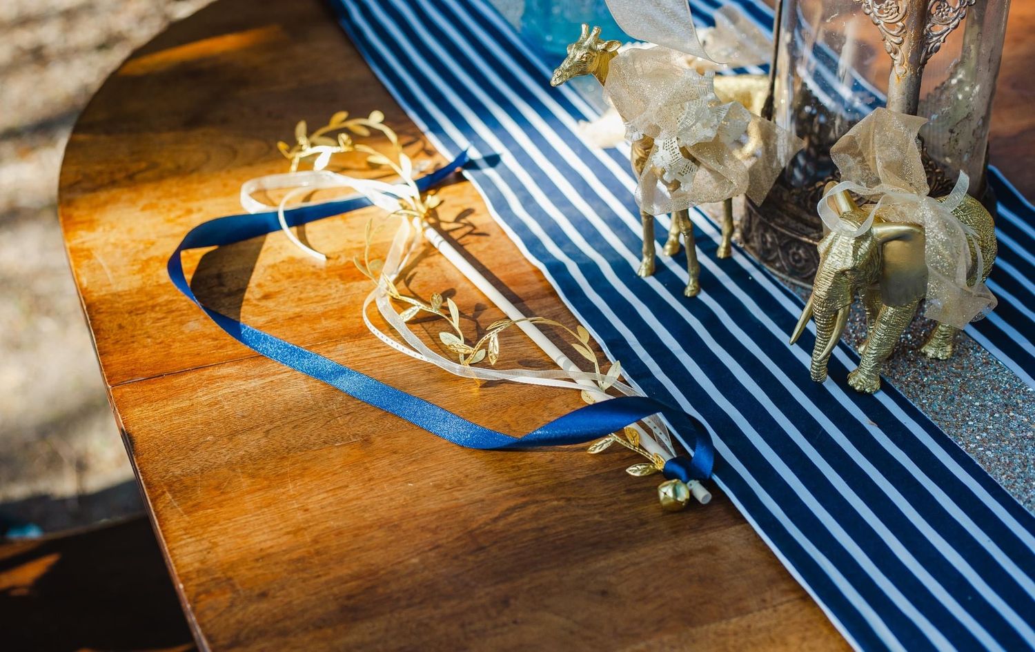 Wedding details with blue and white striped fabric and delicate floral arrangements.