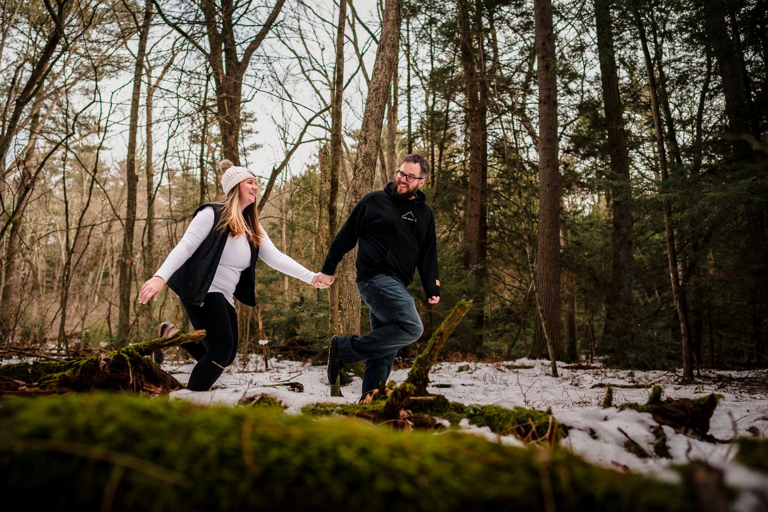 Romantic winter engagement session in a snow-covered forest.