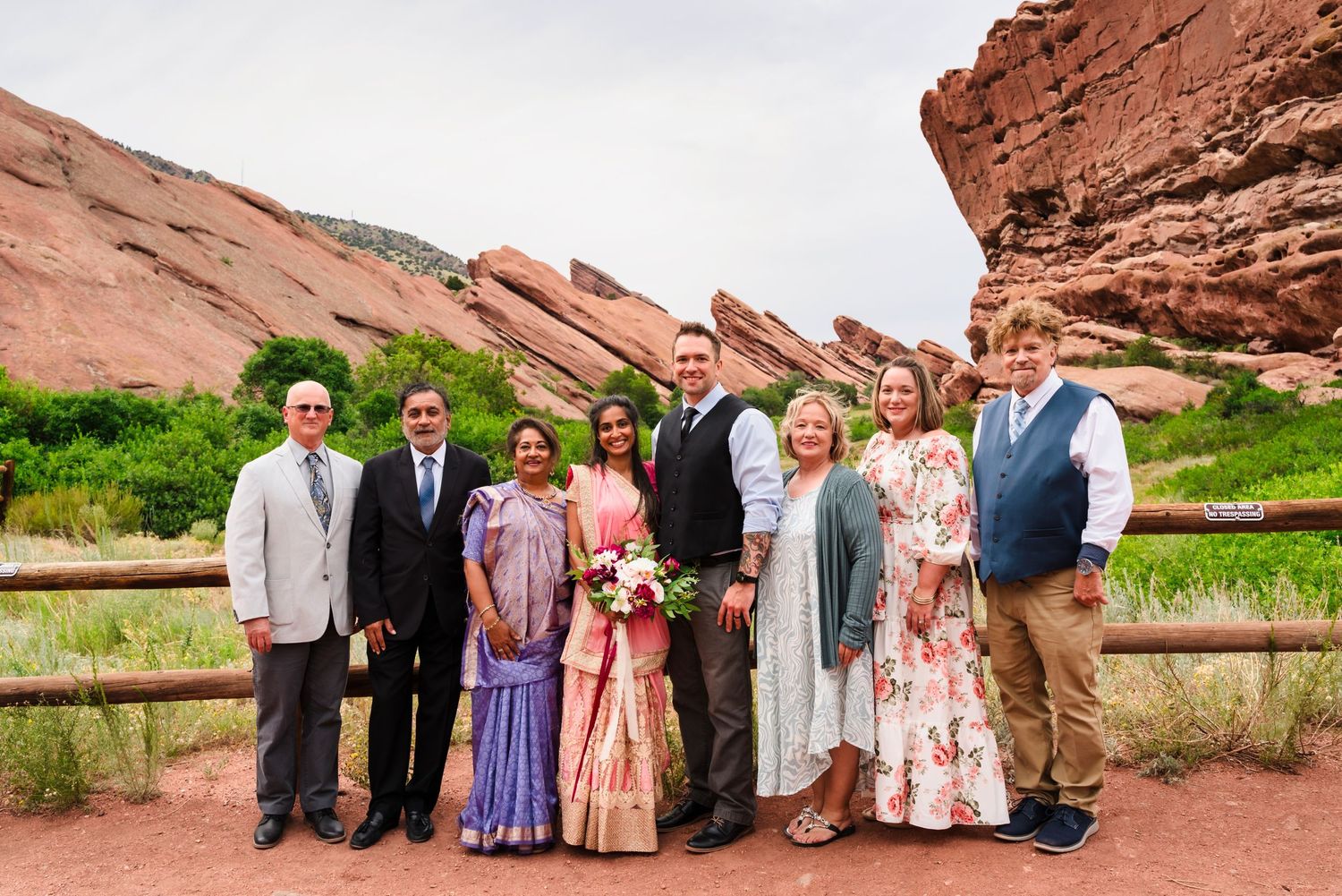 Wedding party poses together at Red Rocks Park with dramatic sandstone formations in the background.