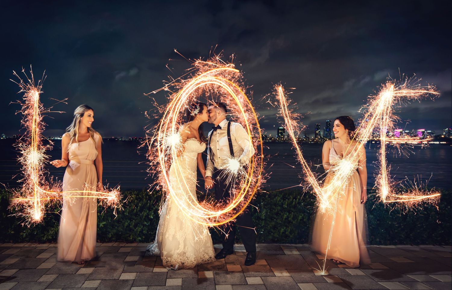 Long exposure sparkler writing spells out LOVE against a dark background.