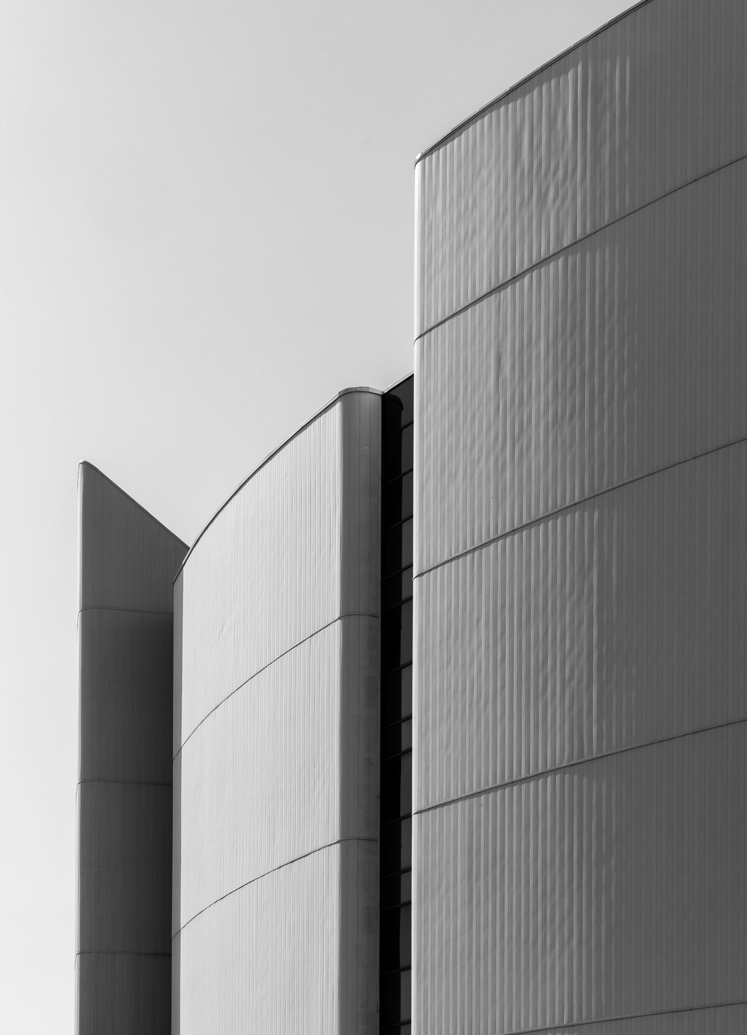 Modern architectural detail of curved white building exterior walls in black and white.