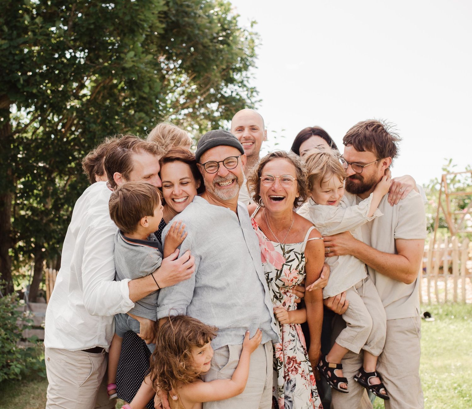 A multi-generational family shares joyful laughter together during an outdoor photoshoot.