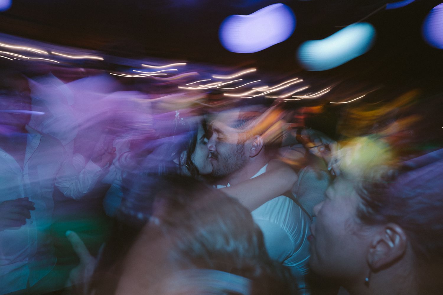 Abstract blurred motion photograph with blue and purple lights creating a dreamy nightclub atmosphere.