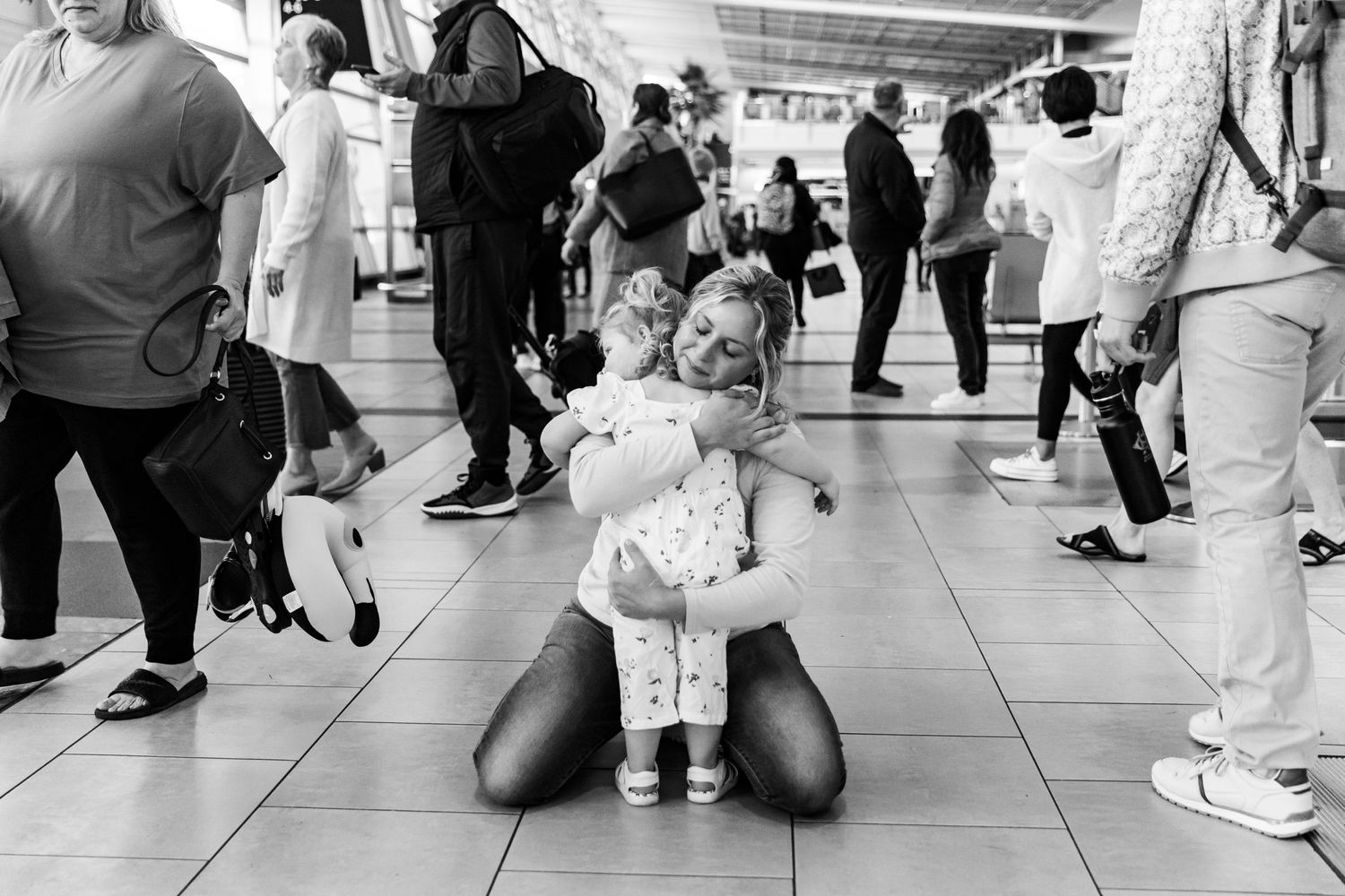 Touching reunion moment between family members at a busy airport terminal.