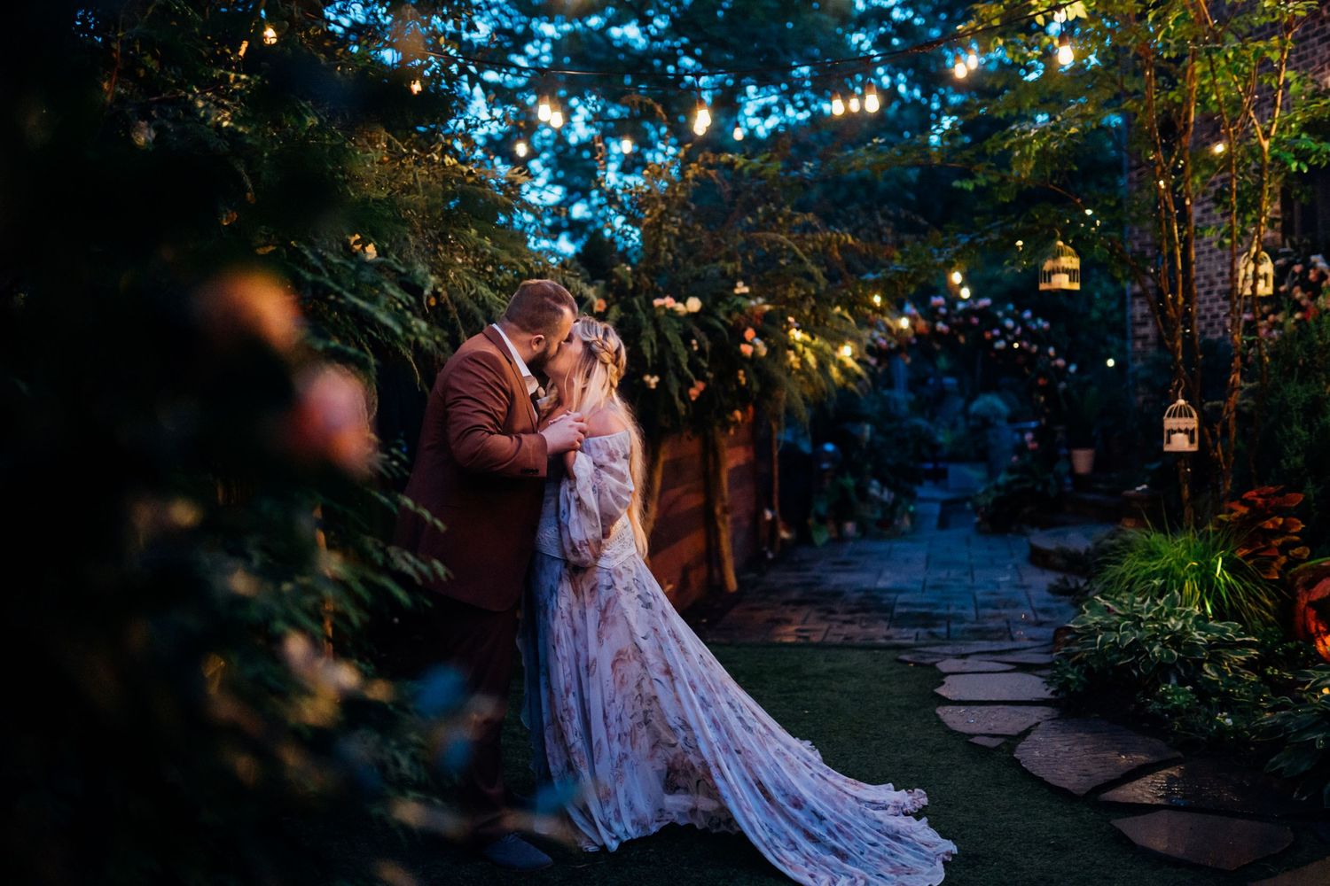 backyard wedding, bride and groom kissing with twinkling lights