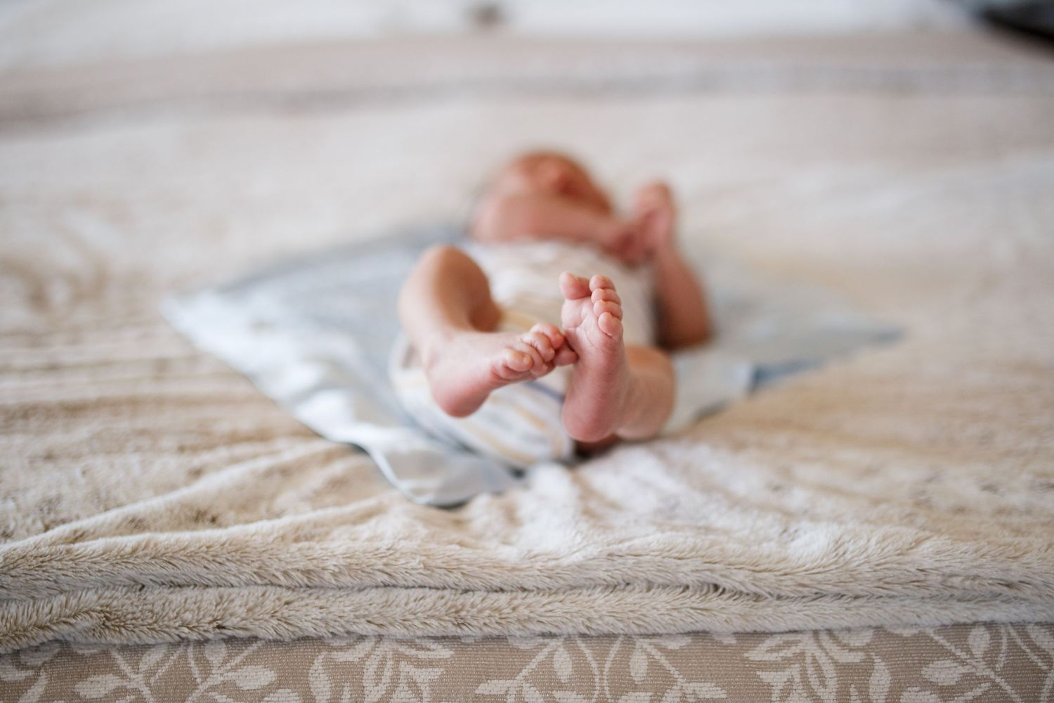 Seattle newborn photographer: a newborn baby on the bed at an in home newborn session