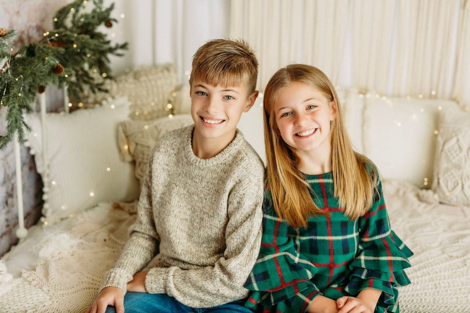 Indoor holiday photo session with decorated Christmas tree and sparkling lights.